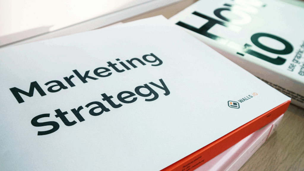 Teczka z dokumentami oznaczona napisem 'Marketing Strategy', ilustrująca planowanie strategii e-mail marketingu i budowanie listy mailingowej z AI.
