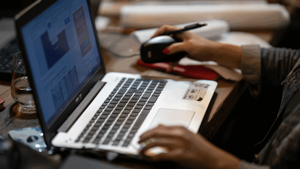 Print-on-demand z grafiką AI — osoba pracująca na laptopie przy biurku